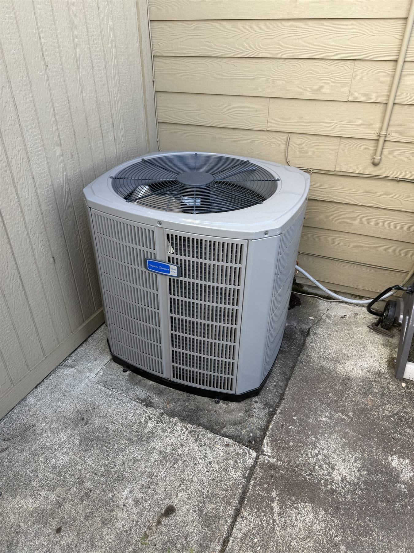An American Standard outdoor unit beside a house
