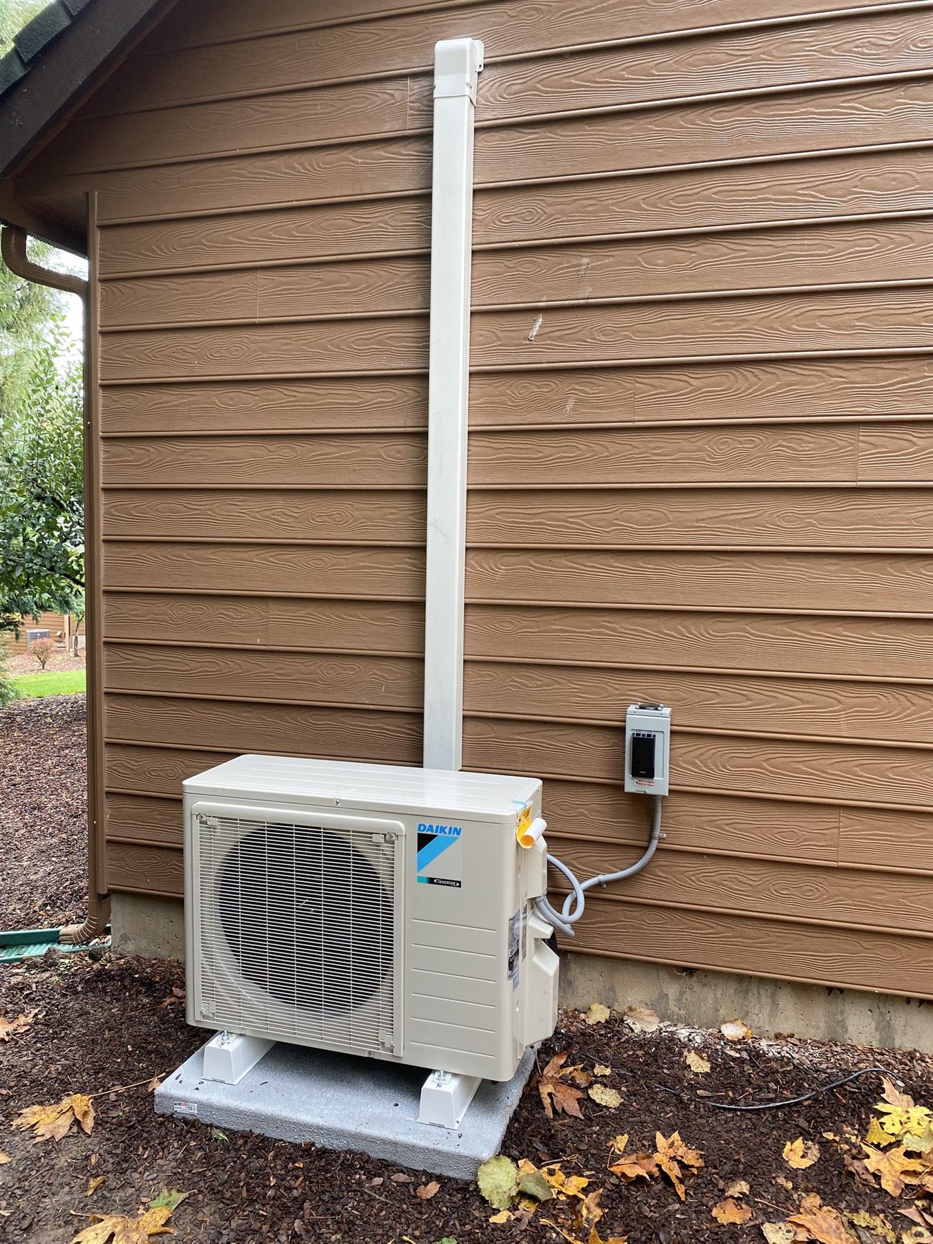 A Daikin outdoor unit on a concrete pad
