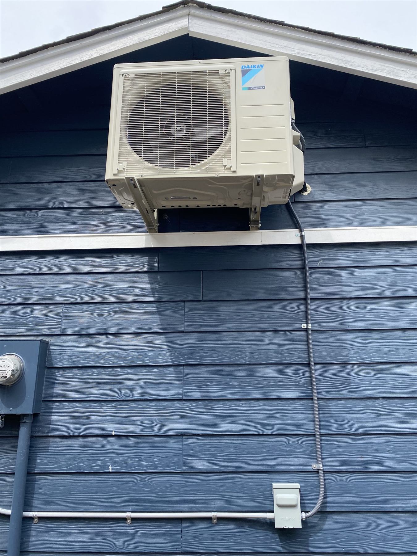 A Daikin outdoor unit mounted on a house wall