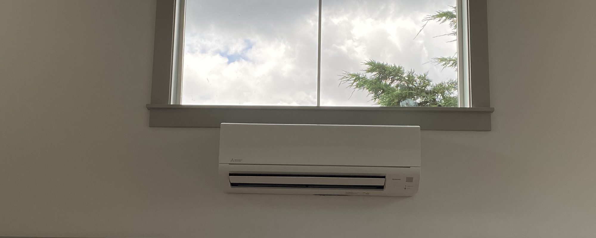A Mitsubishi ductless unit under a high window
