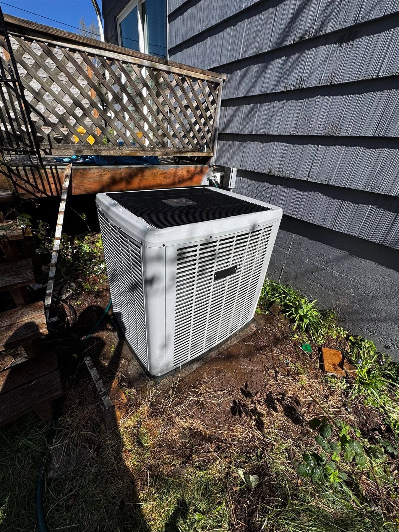 An outdoor condenser installed beside a house